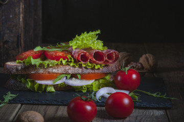 Sandwich with tomato, lettuce leaves and sausage