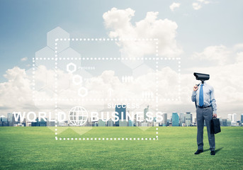 Camera headed man standing on green grass against modern citysca
