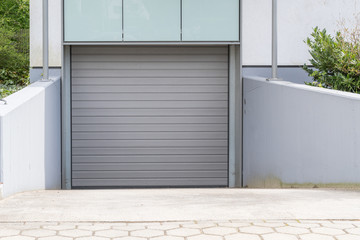 Graues Rolltor einer Tiefgarage mit Einfahrt © GM Photography