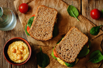 rye sandwiches with hummus, spinch and tomatoes