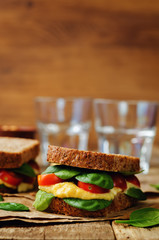 rye sandwiches with hummus, spinch and tomatoes