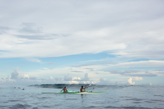 Kayakers and surfers on sea, Tahiti, South Pacific