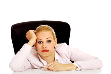 Tired business woman sitting behind the desk