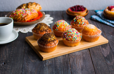 Delicious homemade muffins with yogurt, on a wooden background with space for text.