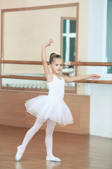 Fototapeta premium Beautiful little girl practicing ballet at class