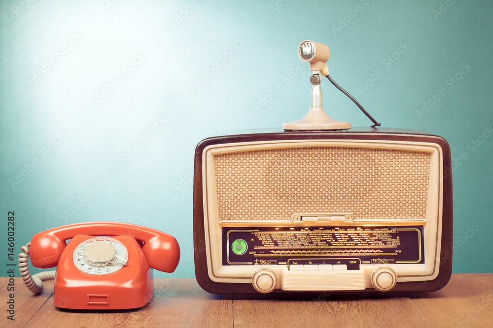 Wall mural retro radio with green light, microphone and telephone on wooden table