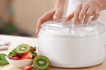 Woman preparing tasty yogurt at home, closeup