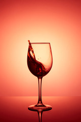 Glass of wine. Red Wine Abstract Splashing. Wine splashing in glass, acrylic background, studio lighting