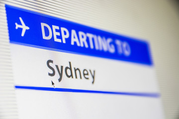 Computer screen close-up of status of flight departing to Sydney, Australia