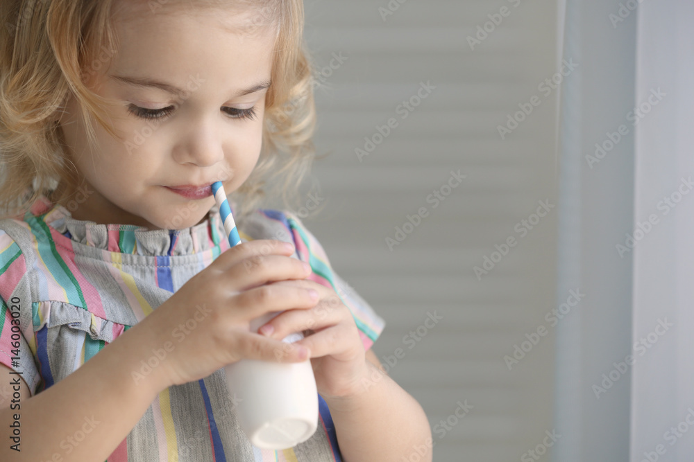 Poster Cute little girl drinking yogurt at home