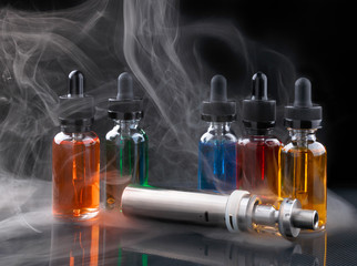 Electronic cigarette and vape liquids within vapor on black background