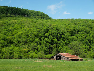 Old Rusted Tin Barn in Arkansas with Mountains in Brackground