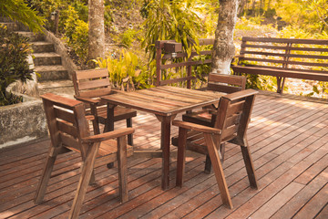 Fototapeta na wymiar Wooden table and chair in resort and garden, dining set at wooden terrace in restaurant.