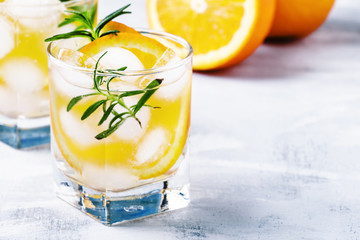 Refreshing drink with orange, rosemary and ice, selective focus