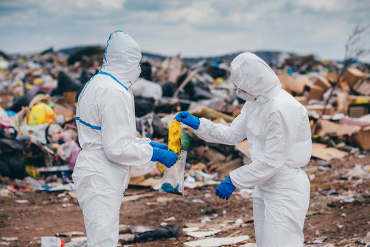 Recycling workers researching on the landfill - Powered by Adobe