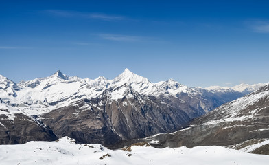 Fototapeta na wymiar snowy Matterhorn peak with blue sky and clouds in background, Switzerland.