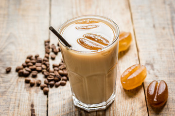 cold coffee glass with ice cubes on wooden table background