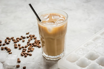 Ice coffee with milk and beans for lunch on stone background