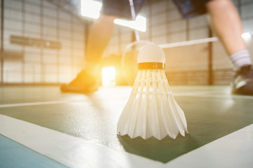 sports concept.Badmintons ball (shuttlecock) and racket ,badminton courts with players competing modern gym in background,selective focus,vintage color