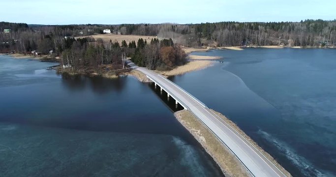 Lohjansaari bridge, Cinema 4k aerial circuling around a bridge, at frozen lohjanj&auml;rvi, near lohjansaari island, on a sunny spring, in Lohja, Finland