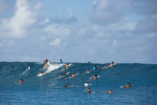 Large group of surfers riding wave, Tahiti, South Pacific