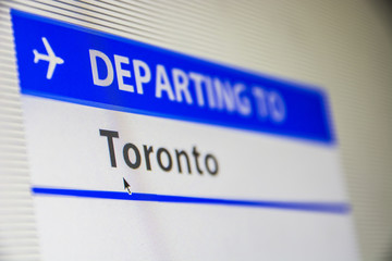 Computer screen close-up of status of flight departing to Toronto, Canada