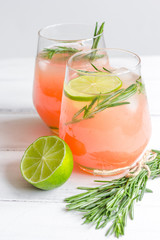 fitness cocktail in glass with lime and rosemary on white table background