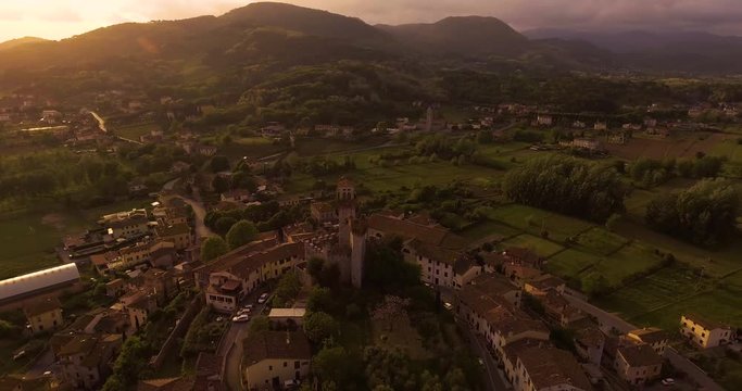 Aerial shot, a small tuscan hamlet Nozzano castello on the hill in the sunset light in Italy, 4K
