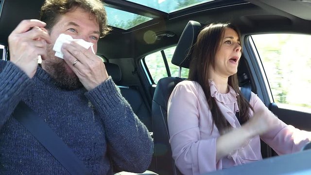 Man sneezing in car while wife is driving