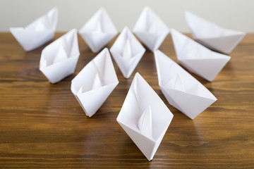 Origami paper boats on a wooden table