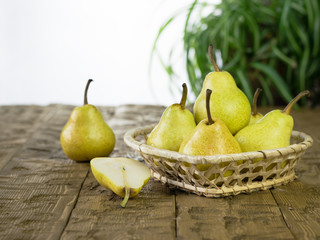 Ripe fresh pears in a pretty basket on the table.