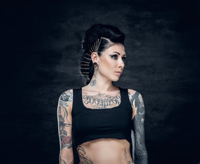 Studio portrait of brunette female with tattoo on her torso.