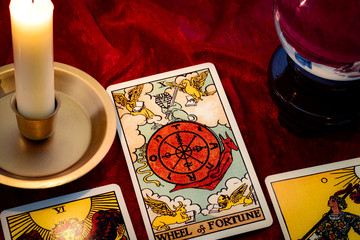 Wheel of fortune card and crystal ball under candle light. Cartomancy is fortune telling using...