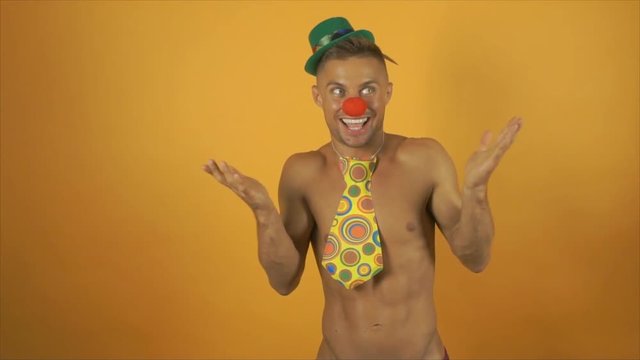 Sexy funny clown with no shirt on. Yellow background.