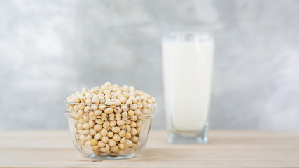 soybean in a bowl and soy milk on a wooden background.