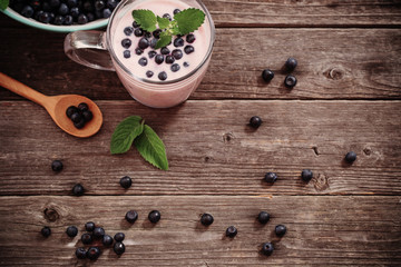 Obraz na płótnie Canvas Yogurt with blueberries on old wooden background