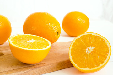 Fresh oranges,cutting board and juicer on white wooden background. Selective focus. Wellness setting. Health concept.