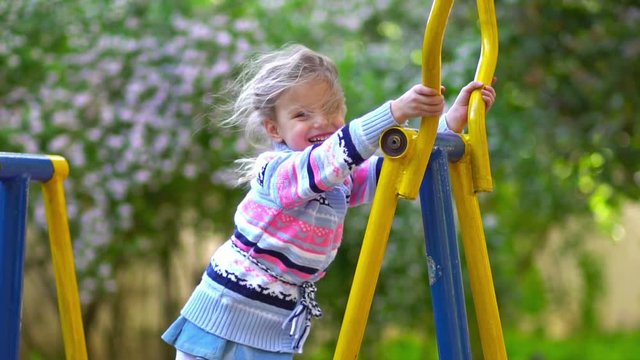 Little girl on playground. Slow motion