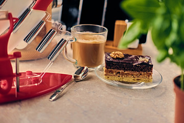Sweet cake, cup of coffee on a table with smart watch, tablet PC and smart phone.