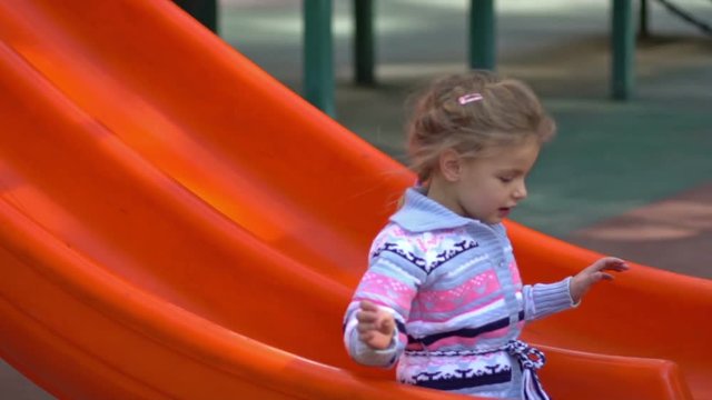 Little girl on playground. Slow motion