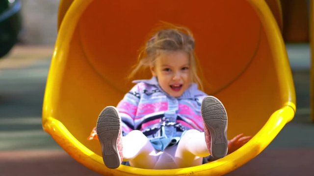 Little girl on playground. Slow motion