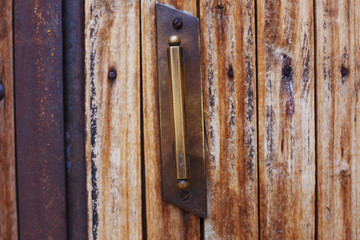 An ancient door handle on wooden door