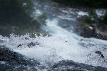 Waterfall in mountains of Norway in rainy weather.