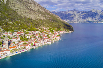 Fototapeta premium Beautiful city with red roofs in the mountains near the sea