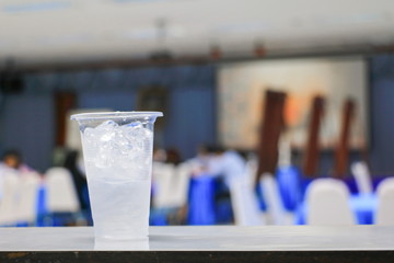 ice water in glass-plastic in seminar conference room background. select focus with shallow depth of field
