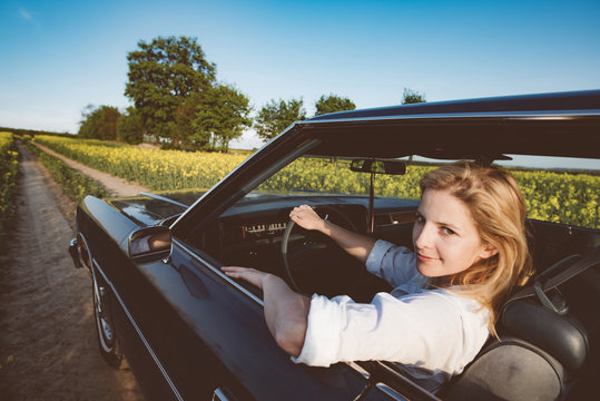 Cute Young Woman Driving A Classic Car