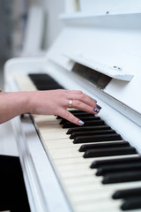 Fototapeta na wymiar Close up of women's hand playing piano
