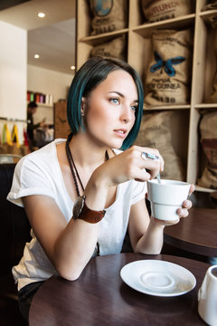 Jeune femme boit une tasse de thé dans un bar