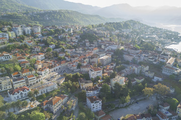 Fototapeta premium Top view of the city streets with red roofs of houses and highways