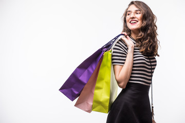 Side view of woman holding shopping bags against white background